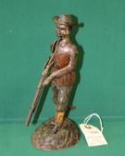 Tinplate Model of what looks to be a hunter dressed in a brown jacket with grey trousers, Orange and
