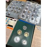 A folder of world coins, a folder of UK coins and a cased coin set.