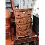 A Victorian walnut bow front bedside chest of drawers.