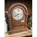 An early 20th century oak cased German 8 day mantel clock with pendulum, key and barley twist