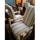 A pair of cream and gilt hightened Frech style armchairs with stiped upholstery.