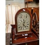An Edwardian inlaid mahogany chiming mantle clock with pendulum and key.