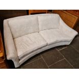 A Laura Ashley cream two seter sofa with brass capped castors.