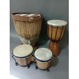 Two African drums and a pair of bongo drums.