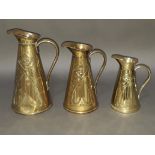 A set of three Art Nouveau graduated brass jugs by Joseph Sankey & Sons, tallest 26cm.
