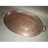 An Arts and Crafts embossed copper tray, twin handles, length 66cm.