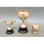 A hallmarked silver trophy, Birmingham, James Fenton, 1937 together with a pair of smaller trophies,