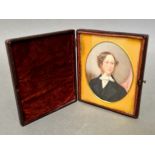 An antique miniature portrait of a gentleman in a fitted case with burgundy velour and glazed.