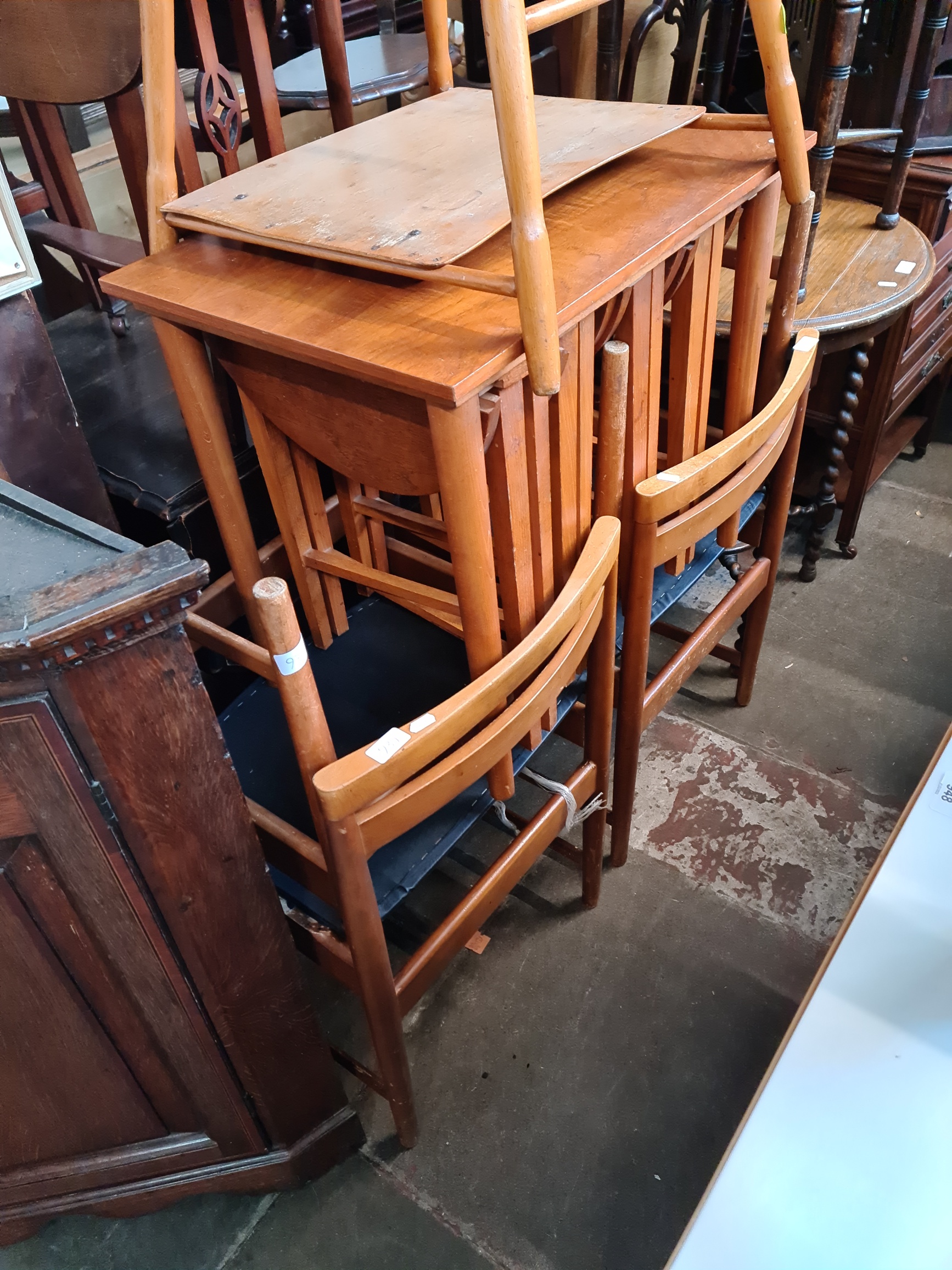 A set of four mid 20th century chairs and a mid 20th century teak nest of folding tables.