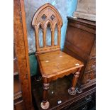 A good quality reproduction oak Gothic style hall chair, height 93cm.