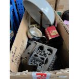 A box of metalware to include trivets, brass candlesticks, old tins, etc.