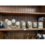 7 domed clocks and 2 carriage clocks, 4 with glass domes and 1 carriage clock with glass casing.