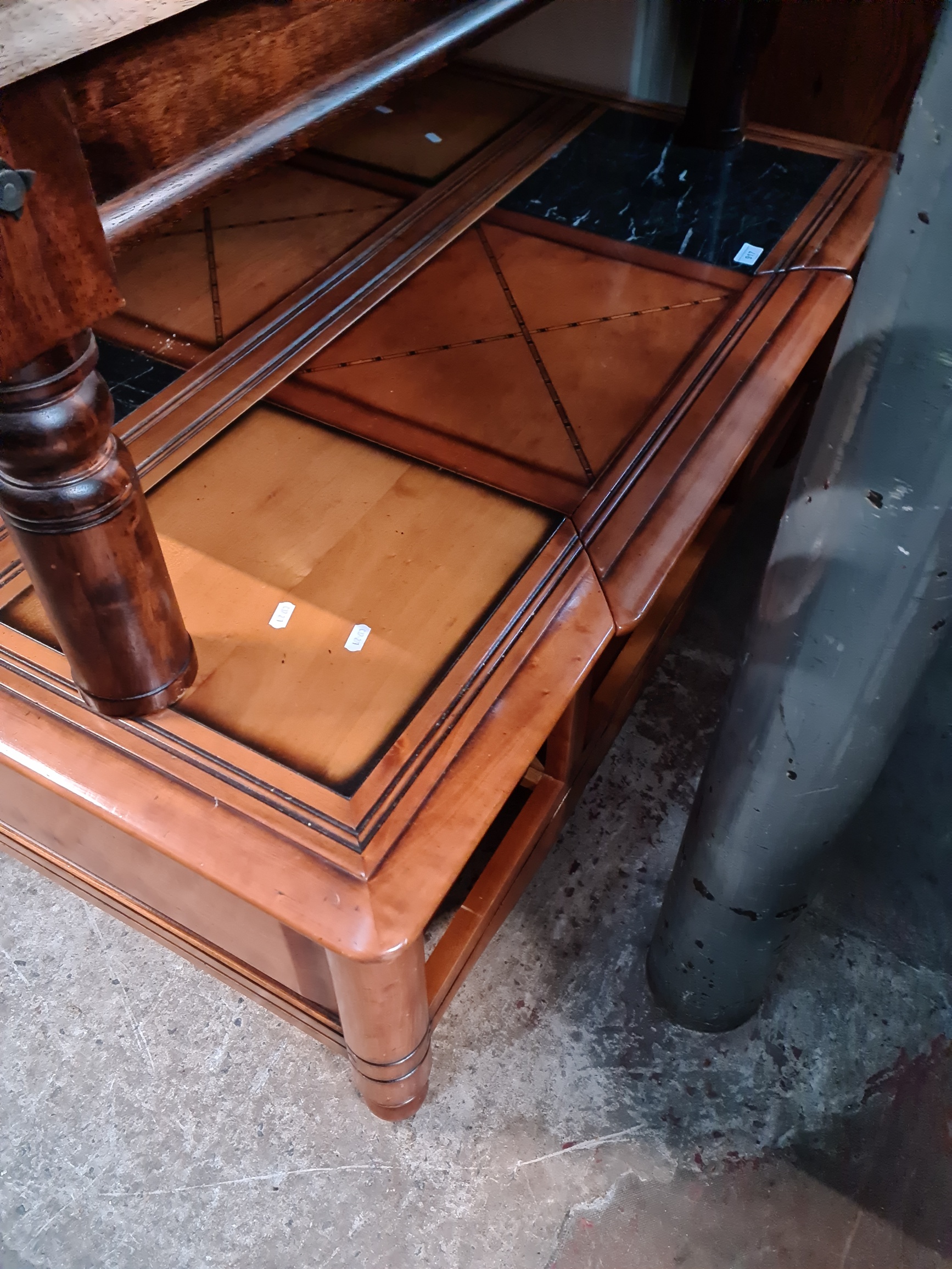 A large inlaid and marble top coffee table with drawers.