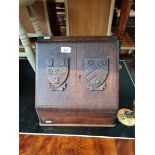 A 1920's oak stationary box with heraldic plaques.