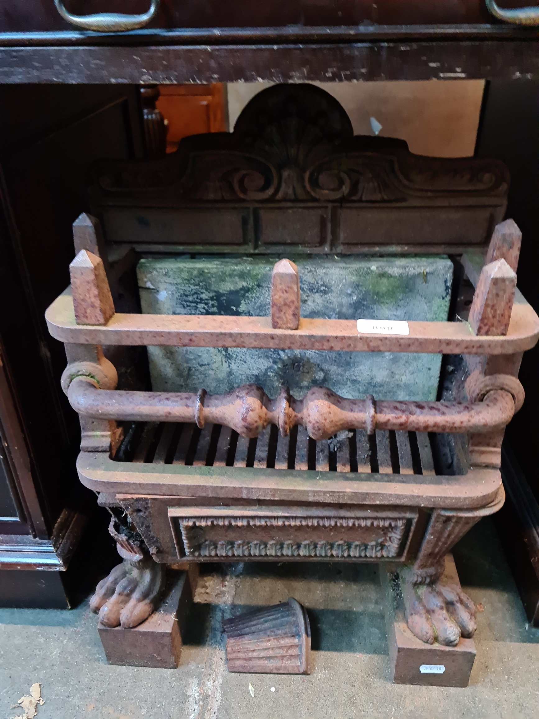 A 19th century cast iron fire basket standing on paw feet.