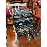 A vintage Royal typewriter and a white painted child's chair.