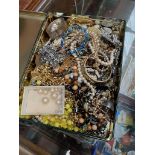 A tin of costume jewellery to include brooches, necklaces, simulated pearls, silver bangle, etc.