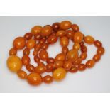 A butterscotch pressed amber bead necklace, the beadsing ranging in length from approx. 8mm to 21mm,