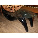 A modern black fibreglass and glass top coffee table, length 125cm.