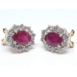 A pair of diamond and flux-healed ruby earrings, the oval clusters measuring approx. 13.80mm x 12.