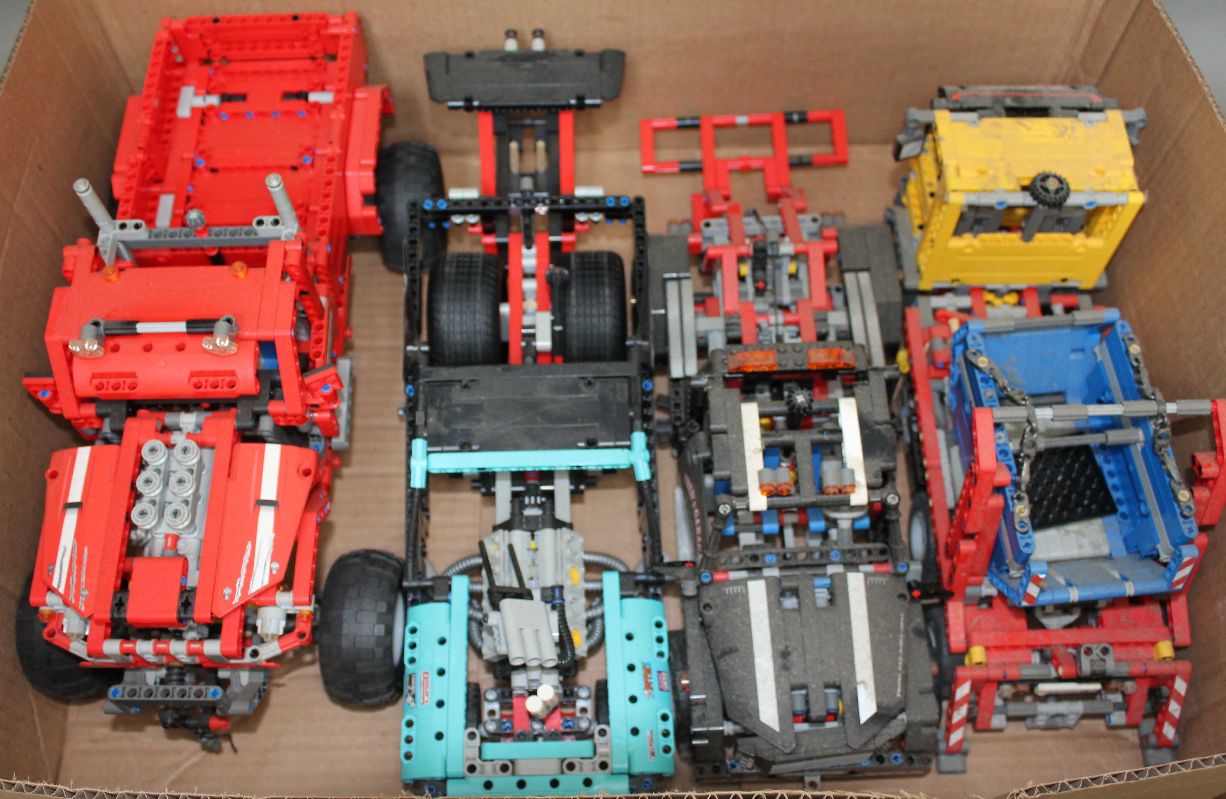 A box containing four Lego Technic models.