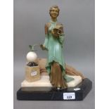 An Art Deco cold painted spelter figure of a lady holding a dove on marble base.