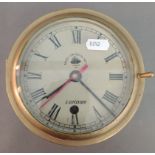 An antique brass ship's clock "Made for Royal Navy" London, 1920 with thick glass.