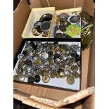 A box of vintage badges and military buttons.