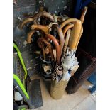 A brass and a ceramic stick / umbrella stands containing various vintage walking sticks and