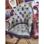 A green leather Chesterfield desk chair.