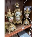 A reproduction gilt metal and porcelain clock garniture