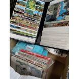 A box of postcard albums and loose postcards.