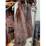 A vintage stranded skunk fur coat together with a white fur cape and a vintage feather boa.