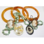 Assorted costume jewellery including imitation amber bangles, green hard stone beads, shell cameos
