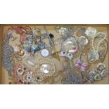 A box of assorted costume jewellery including a moon face pendant, some named pieces etc.