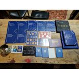 A box of assorted GB coin sets, albums and a tin of world coins, some incomplete & some empty.