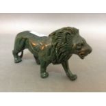 A green hardstone jade style carving of a lion.