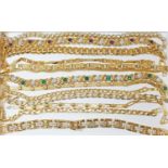 A group of thirteen gold plated bracelets.