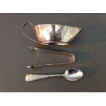 Three pieces of hallmarked silver comprising a cream jug, a pair of sugar tongs and a spoon, gross
