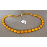 A strand of graduated bakelite beads with a 9ct gold clasp.