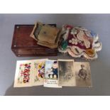 A antique box with mother of pearl inlay containing various WW1 military postcards to include 2 silk