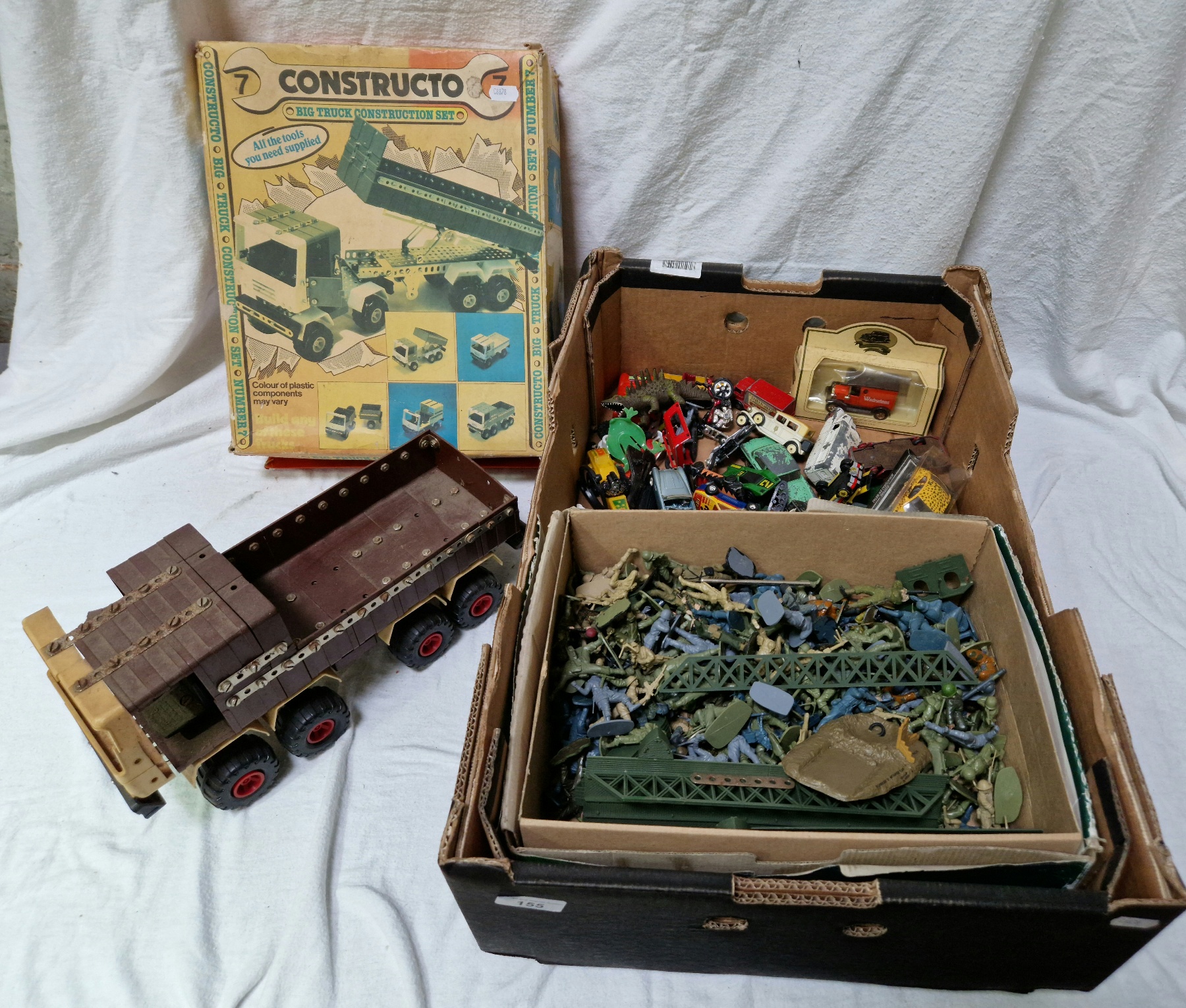 A box of vintage toys to include assorted diecast vehicles, plastic toy soldiers and a Constructo
