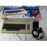 A boxed C64 micro computer with joystick & power adaptor.