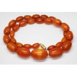 A graduated butterscotch pressed amber bead necklace, the oval beads ranging in length from