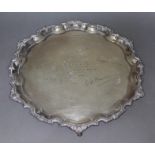 An Elizabeth II three footed silver salver with scallop edge, presentation inscription to centre,