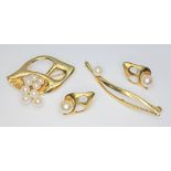 A suite of pearl set jewellery comprising two brooches and a pair of earrings, 18ct gold import
