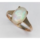An opal ring, the oval flat bottom opal cabochon measuring approx. 10mm x 7mm x 4mm, marked '9ct',