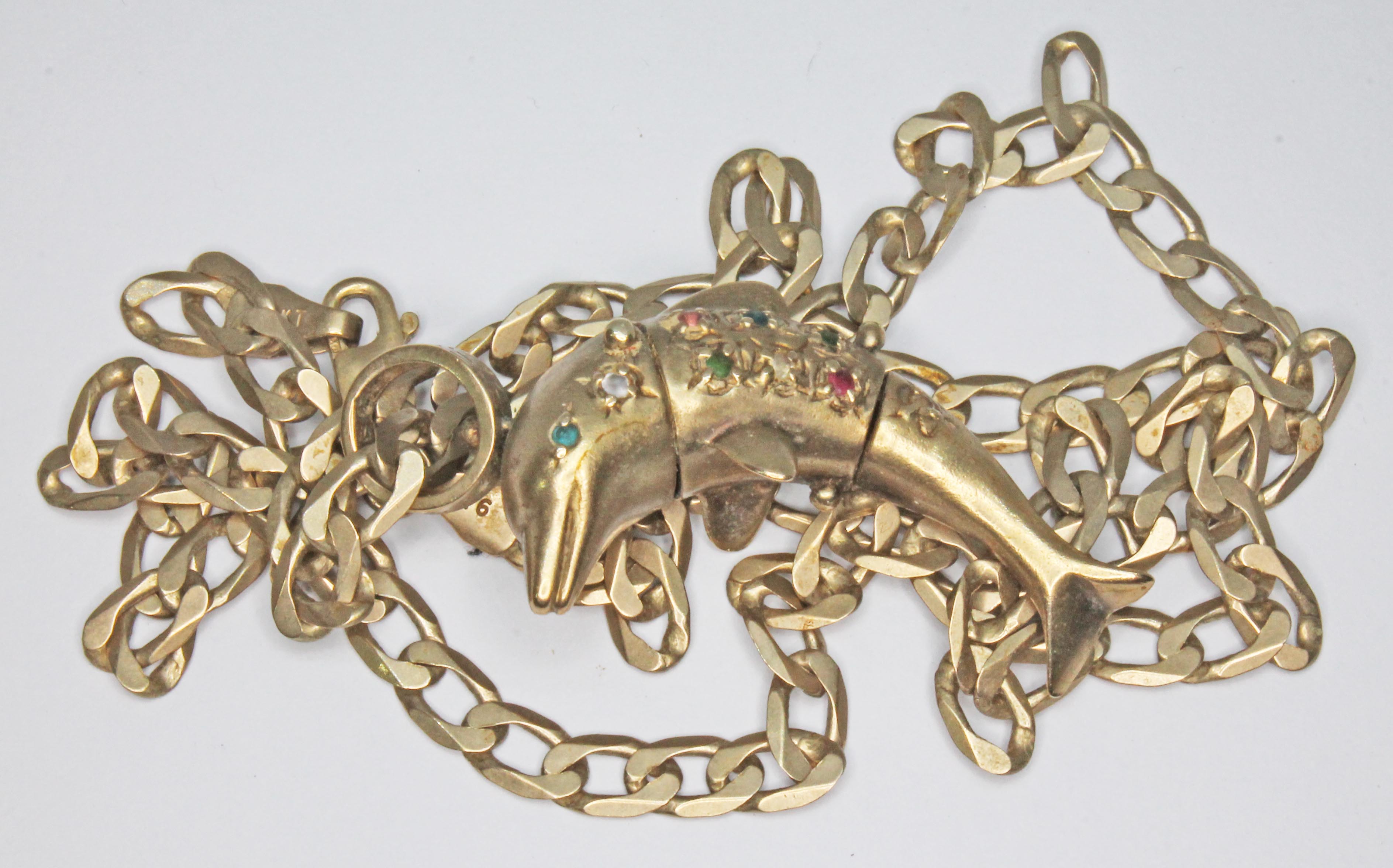 A novelty multi-gem set pendant modelled as a dolphin on 44cm chain, both hallmarked 9ct gold, gross
