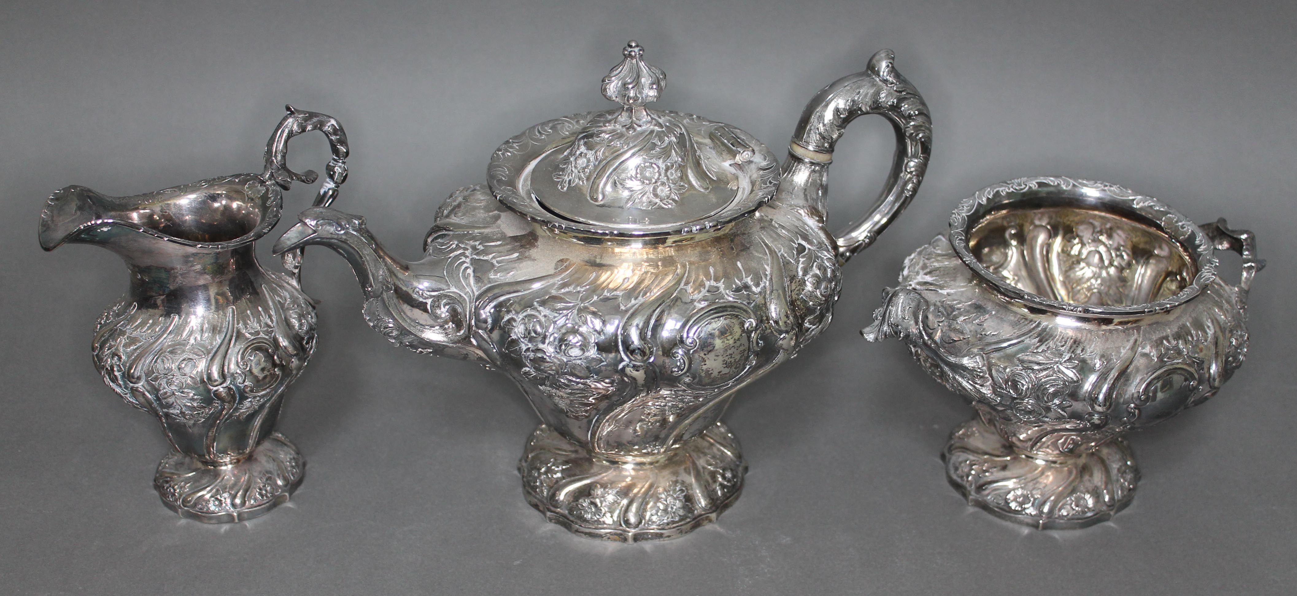 A William IV Scottish silver tea set, repousse decoration depicting floral bouquets and scrolls,