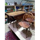 A vintage Ercol beech and elm drop leaf table and four Ercol 'Windsor' chairs.